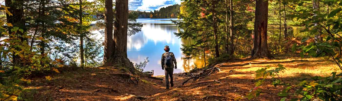 A man walking down a wooded path toward a secluded spot at Lake Champlain, in Clinton County, NY.