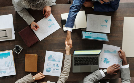A group of people going over data tables and charts at a business meeting