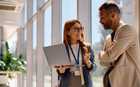 Two business colleagues discussing information on a laptop